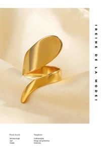Detail eines 18K vergoldeten Spiralrings auf elegantem champagnerfarbenem Seidenstoff