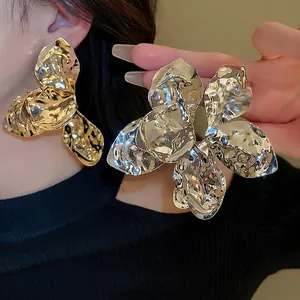 Große unregelmäßige Blumenohrringe mit plissierter Metallstruktur in Gold- und Silberoptik