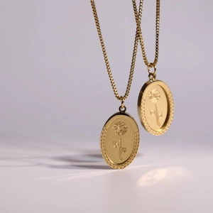 Close-up of double-layered gold stainless steel necklaces with oval rose flower pendants