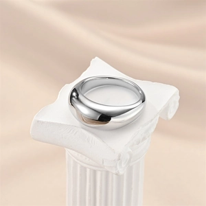 Polished silver titanium steel teardrop ring on white Greek column pedestal display