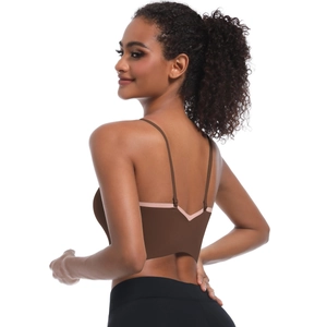 Detail of cross-back yoga bra showing thin straps and pink contrast trim on brown fabric