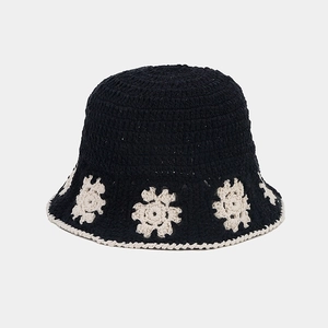 Handmade crochet bucket hat in black with white floral patterns and knit brim details