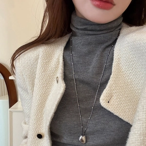 Minimalist silver chain necklace with geometric double-layer pendant on tweed jacket