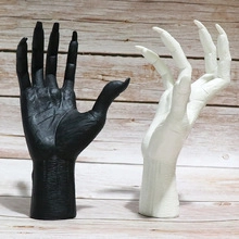 Detail of 3D-printed black and white alien hand sculptures for home and garden decor