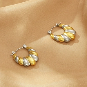 Boucles d'oreilles en U bicolores avec texture en spirale sur tissu de soie dorée