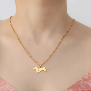 Golden dachshund pendant necklace with heart detail worn by model showing length and fit