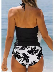 Halter neck black bikini top with palm leaf print bottoms shown from the back view