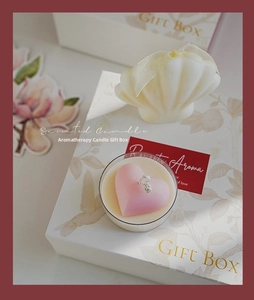 Detail of a scented candle gift box with shell and heart shapes in warm natural lighting