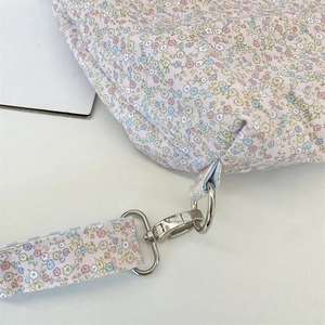 Detailed close-up of floral print canvas bag showing durable metal hooks and stitching