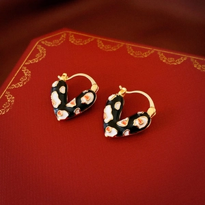 Boucles d'oreilles cœur dorées vintage avec émail léopard sur une boîte à bijoux