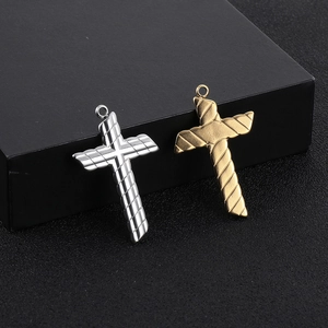 Detailed view of silver and gold stainless steel cross pendants with diagonal stripe textures