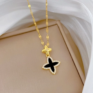 Detail of gold star and black clover pendant necklace with sparkling rhinestones