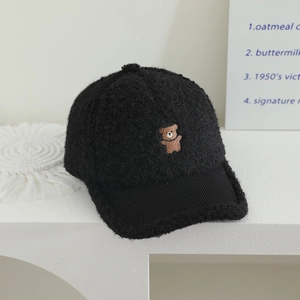 Close-up of black teddy fleece baseball cap with cute brown bear embroidery detail