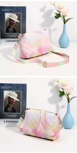 Detail of the diamond-quilted gradient texture and adjustable fabric strap on a bag