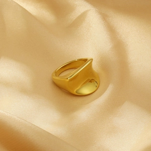 Detailed view of polished 18K gold plated irregular geometric ring on satin fabric