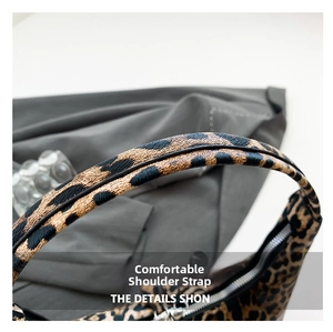 Detail shot of wide leopard print shoulder strap and metal zipper on the bucket bag
