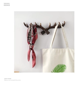Close-up of vintage deer antler wall hook showing resin wood texture and storage usage