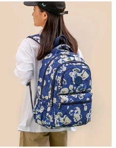 Blue floral oxford backpack shown on model highlighting spacious capacity and multiple pockets