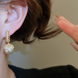 Detail of gold-plated pearl drop earrings with crystal lace and French vintage design
