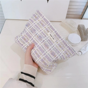 Detail of tweed makeup bag in lilac and white with simple wish woven label