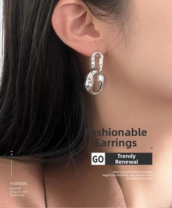 Detail view of silver layered hoop earrings with irregular flowing lines on model