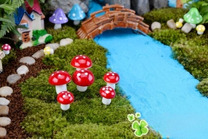 Mini funghi rossi a pois in una decorazione da giardino con micro paesaggio