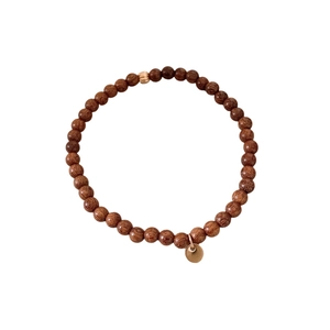 Sandalwood beaded bracelet with a single gold bead and round metal charm for women