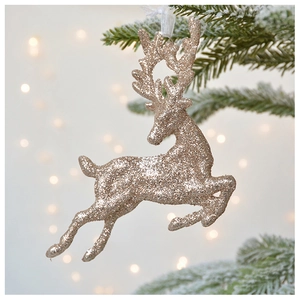 Champagne gold glitter reindeer ornament hanging on a snowy Christmas tree branch