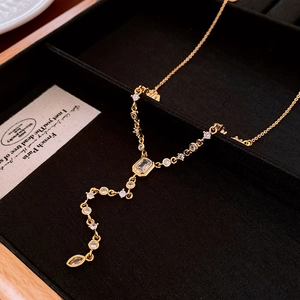 Detail of a gold plated Y-shaped necklace with sparkling cubic zirconia on black velvet