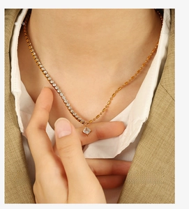 Détail du collier en or avec pendentif en cristal asymétrique sur chemise et blazer