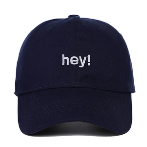 Détail de la casquette marine en coton avec broderie blanche 'hey' en relief sur le devant
