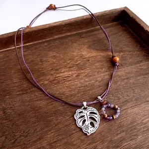 Retro ethnic necklace with hollow monstera leaf pendant, purple beads and wooden accents