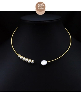 Detail of open gold choker featuring five small pearls and one baroque pearl on a neck model