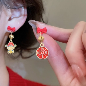 Macro view of Chinese lion dance earrings with red bow and gold fortune characters