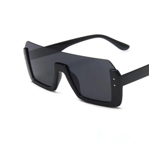 Detail van een zwarte oversized vierkante flat-top zonnebril met dik plastic montuur en glazen