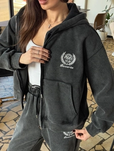 Détail d'un ensemble sweat à capuche et jogging gris foncé délavé avec écusson brodé