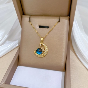 Luxurious gold star and moon necklace with blue gemstone and diamonds in a jewelry box