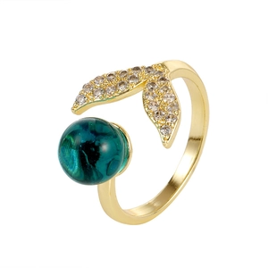 Elegant gold fishtail open ring featuring a dark teal gem and sparkling cubic zirconia