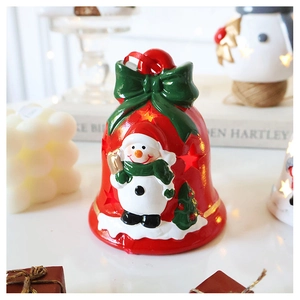 Detail of luminous snowman Christmas bell with green bow and festive LED lights decoration