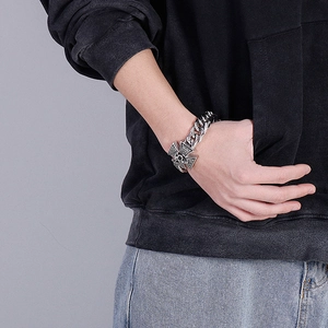 Detail of silver cross and skull embossed links on a punk style stainless steel bracelet