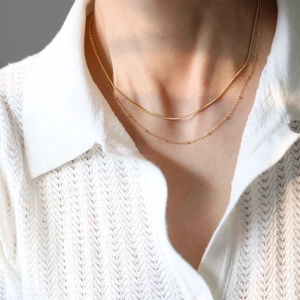 Close-up of minimalist layered 18K gold plated snake and bead chain necklace for women