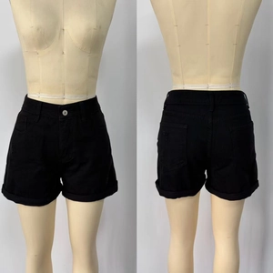 Dettaglio degli shorts in denim nero a vita alta con orlo risvoltato su un manichino