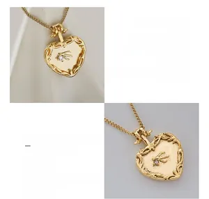 Détail du pendentif cœur plaqué or 18 carats avec gravure d'hirondelle et zircon serti