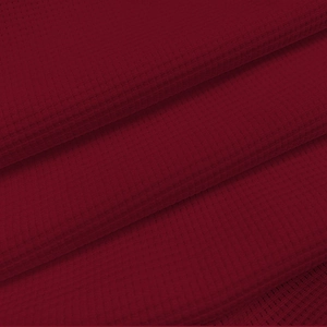 Macro shot of dark red waffle knit fabric texture showing honeycomb weaving detail