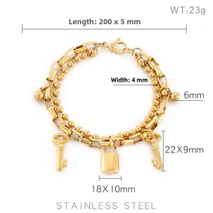 Detail view of double-layer stainless steel bracelet with padlock and key charms