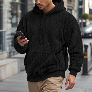 Detailed close-up of high-street men's black hooded sweatshirt in soft jacquard teddy fleece