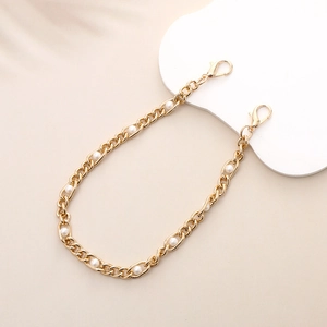 Detailed macro view of golden metal rings and white pearls on an elegant lanyard