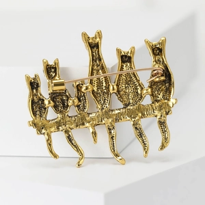 Detailed back view of golden cat brooch featuring safety pin clasp and metal structure