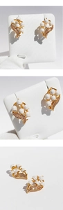 Three-way view of lily of the valley earrings with white enamel and golden leaf detailing