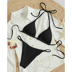 Sexy black ribbed halter bikini set with tie-side triangle bottom on beach vacation props